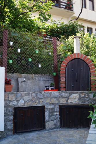 two wooden garage doors on a stone wall at Snegar Apartments in Ohrid