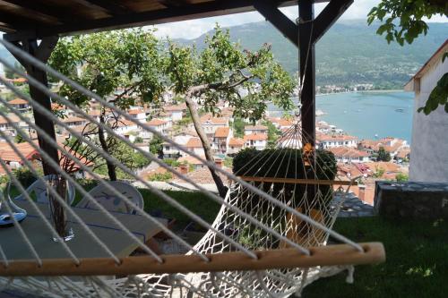 a hammock with a view of a town and a lake at Snegar Apartments in Ohrid