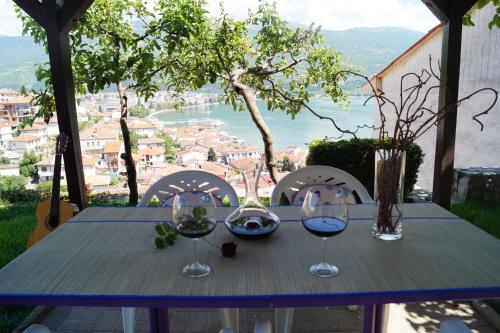 a blue table with glasses of wine on a balcony at Snegar Apartments in Ohrid