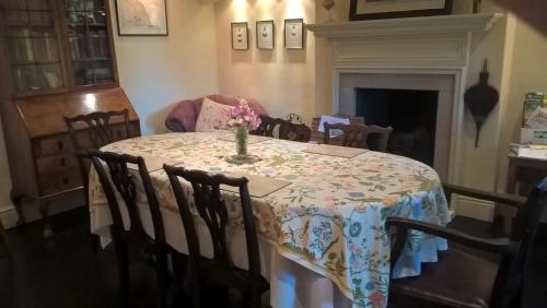 een eettafel met een vaas met bloemen erop bij Thorpe Green House Vegetarian Bed & Breakfast in Robin Hood's Bay