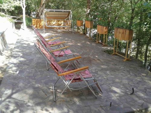 a row of wooden chairs sitting on a patio at Park-Hotel Khoren's Lake in Areni