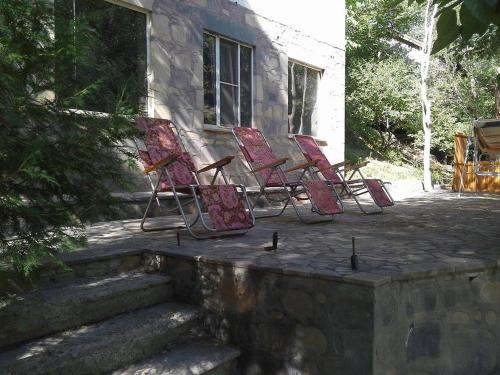 a group of chairs sitting outside of a house at Park-Hotel Khoren's Lake in Areni