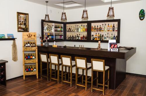a bar with five stools in a room at Yeghevnut Hotel in Goris