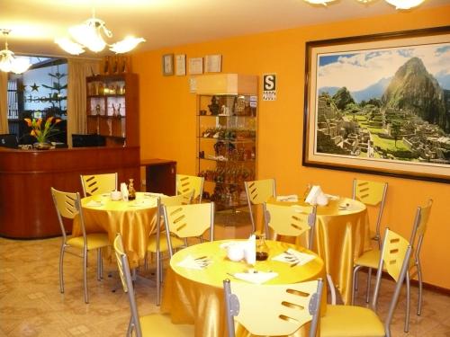 un restaurante con mesas amarillas y sillas amarillas en Hostal El Imperio, en Arequipa