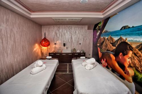 a room with two beds and a painting on the wall at Wellness & Spa Hotel ACD in Herceg-Novi