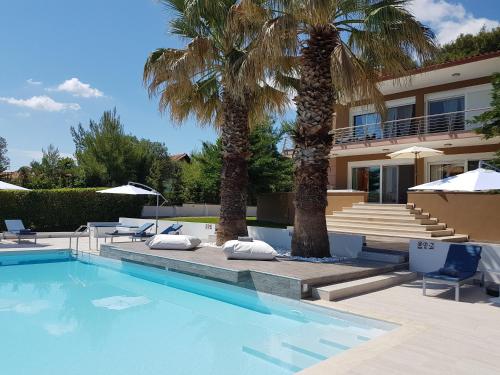 a villa with palm trees and a swimming pool at Villa Anna Maria in Kriopigi