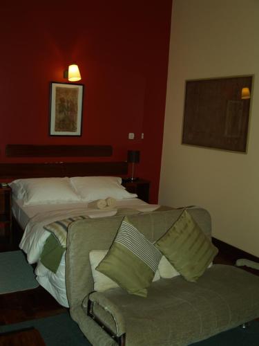 a living room with a couch and a bed at Palmeiras Guest House Maputo in Maputo