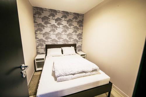 a small bedroom with a bed with white sheets at Renovated Apartment in Antwerp city center in Antwerp