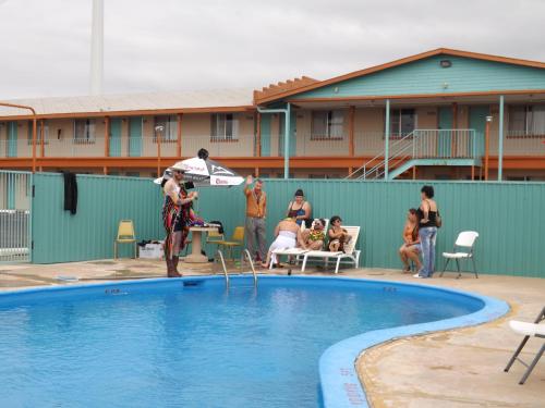 a man holding a frisbee in front of a swimming pool at Tristar Inn Xpress in Tucumcari
