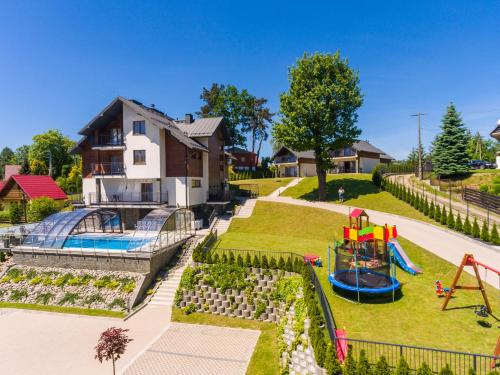 a backyard with a playground and a slide at Na Wzgórzu FAMILY RESORT in Gródek Nad Dunajcem