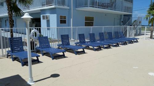 a row of blue chairs in front of a building at Knight's Key Suites in Marathon