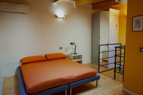 a bedroom with a bed with an orange blanket at Studio Apartment Vicolo Lavandai in Milan