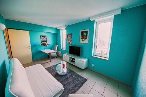 a blue room with a couch and a television at Renovated Apartment in Antwerp city center in Antwerp