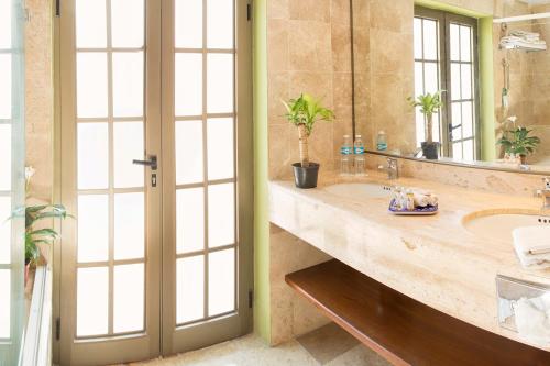 a bathroom with two sinks and a large mirror at Hotel Los Itzaes by 5th av in Playa del Carmen