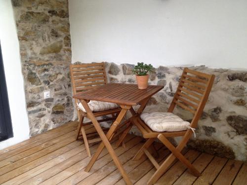 a wooden table and two chairs with a plant on it at Casas Do Contrabando in Marvão