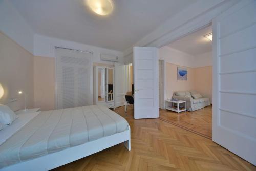 een witte slaapkamer met een bed en een bureau bij Oasis veranda under columns.Kolonaki embassy area. in Athene