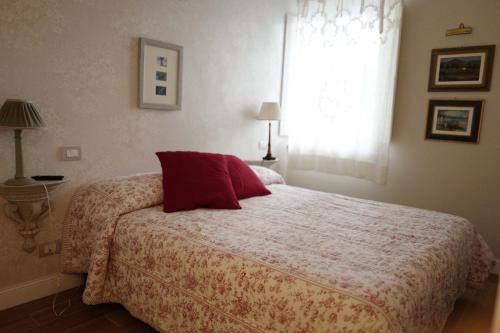 a bedroom with a bed with a red pillow and a window at Sweet Central appartment in San Benedetto del Tronto