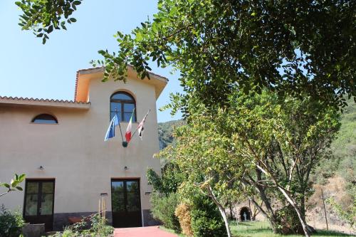 a house with a flag on the side of it at Ostello Su Mannau in Fluminimaggiore