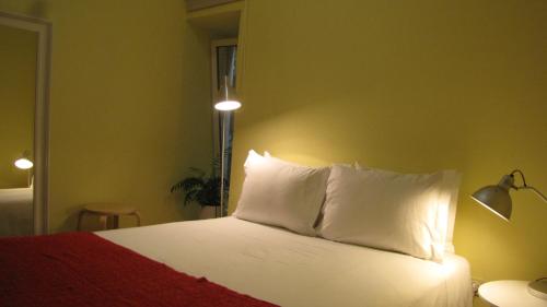 a bedroom with a bed with white sheets and pillows at Foz Gardens in Porto