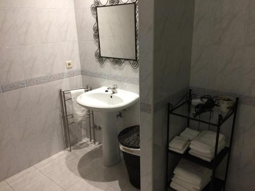 La salle de bains est pourvue d'un lavabo, d'un miroir et de serviettes. dans l'établissement Downtown PORTO SE, à Porto