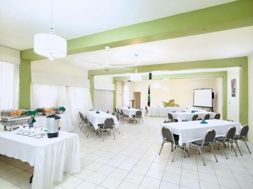 a large room with white tables and chairs and a screen at Shirley Retreat in Kingston