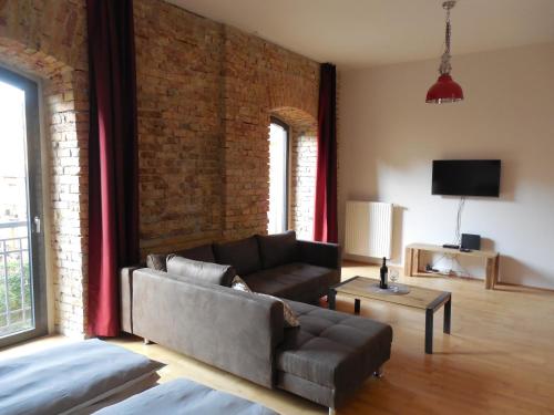 a living room with a couch and a brick wall at The Old Mill Budapest in Budapest