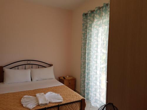 a bedroom with a bed and a window with towels at Villa Xani in Himare