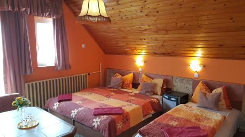 1 dormitorio con 2 camas y techo de madera en Rózsa Panzió, en Balatonfüred