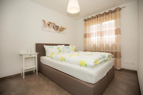 a bedroom with a large bed with a window at Family Apartments in Rust