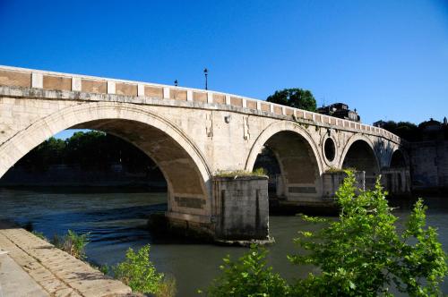 eine Steinbrücke über einen Fluss mit Wasser in der Unterkunft Lofts In Rome in Rom