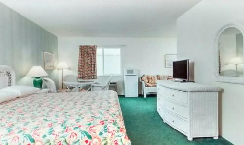 a bedroom with a bed and a television in a room at Super 8 by Wyndham Reedsburg in Reedsburg