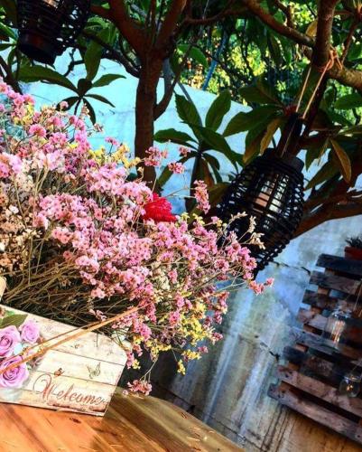 a bunch of pink flowers in a basket on a table at Affittacamere Casa Mac & Rose in San Quirico dʼOrcia