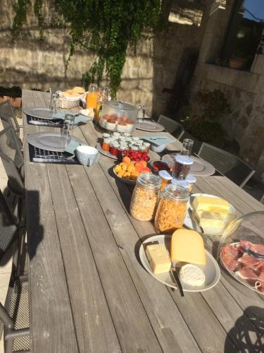 a wooden table with food on top of it at Abacard Home Chambre d'Hôtes adult only in Roquemaure