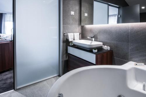 a bathroom with a white tub and a sink at Best Western Premier Natalija Residence in Belgrade