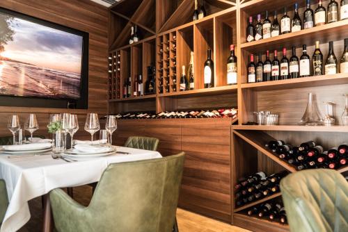 a restaurant with a table and wine bottles at Best Western Premier Natalija Residence in Belgrade