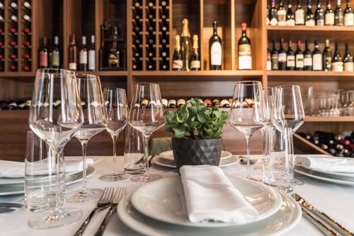 a table with wine glasses and plates on it at Best Western Premier Natalija Residence in Belgrade
