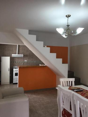 a living room with a staircase and a kitchen at Altos del Tala Deptos - Cabañas in Embalse