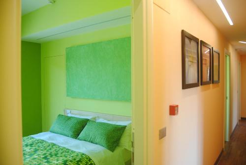 1 dormitorio con paredes de color verde y amarillo y 1 cama en Affittacamere Stazione Valmontone en Valmontone