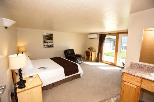 een hotelkamer met een bed en een stoel bij Ninepipes Lodge in Polson