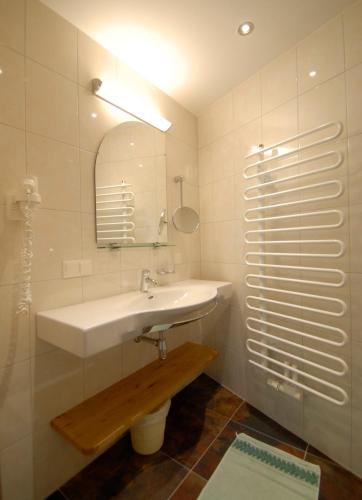 a white bathroom with a sink and a mirror at Berghaus Koglmoos in Auffach