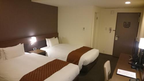 Ένα ή περισσότερα κρεβάτια σε δωμάτιο στο Hotel Ascent Plaza Hamamatsu