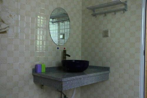 a bathroom with a black sink and a mirror at Zhangjiajie one step to heaven inn (Yangjiajie ticket office) in Zhangjiajie