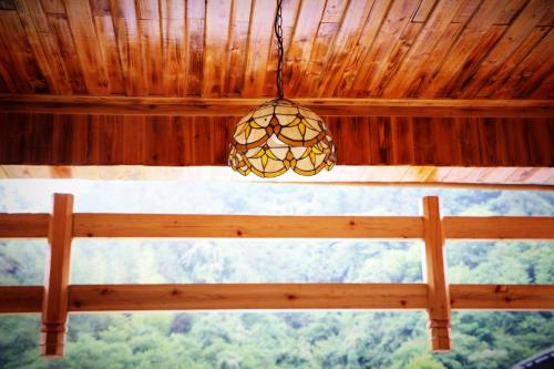 a chandelier hanging from a wooden ceiling with a window at Zhangjiajie one step to heaven inn (Yangjiajie ticket office) in Zhangjiajie