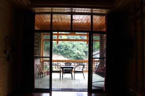 an open door to a patio with a table and chairs at Zhangjiajie one step to heaven inn (Yangjiajie ticket office) in Zhangjiajie