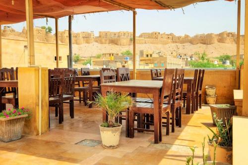 ein Restaurant mit Tischen und Stühlen und Blick auf ein Schloss in der Unterkunft Hotel Royal Haveli in Jaisalmer