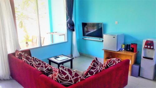 Televízia a/alebo spoločenská miestnosť v ubytovaní Villa Rembulan