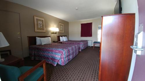 a hotel room with two beds and a door at Best Budget Inn Tell City in Tell City