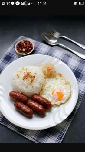 a plate of food with sausages and eggs on a table at BATAD CRISTINA'S Main Village INN & Restaurant in Banaue