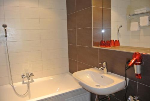 a bathroom with a white sink and a shower at Hotel Restaurant Jura in Kerzers