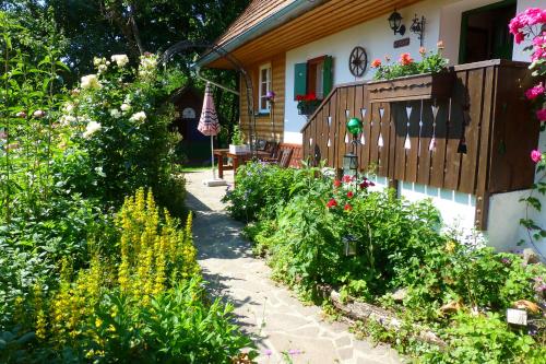 a garden in front of a house with flowers at Altes Gehöft am Lormanberg in Kirchberg an der Raab